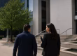 Criminal defence lawyer accompanying a client toward a courthouse