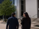 Criminal defence lawyer accompanying a client toward a courthouse
