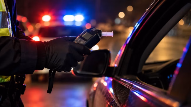 Officer holding a roadside screening device, illustrating refusing a breathalyzer in Ontario
